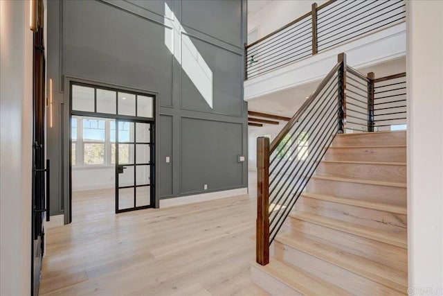 staircase featuring hardwood / wood-style floors and a high ceiling