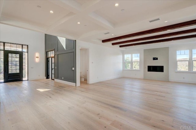 unfurnished living room featuring beamed ceiling and light hardwood / wood-style floors