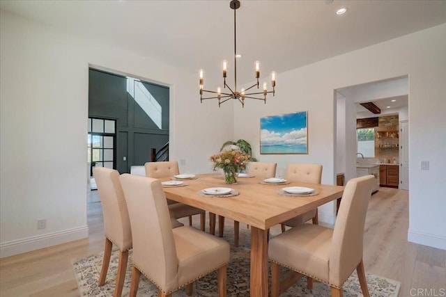 dining space featuring light hardwood / wood-style floors, an inviting chandelier, and a wealth of natural light