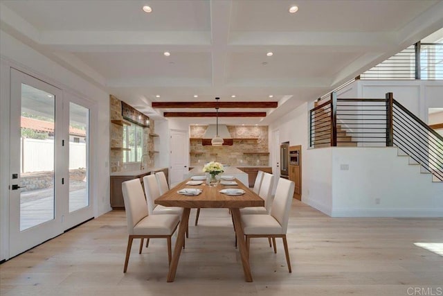 dining room with beamed ceiling and light hardwood / wood-style floors