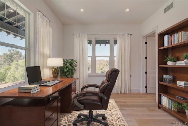 home office with a healthy amount of sunlight and light wood-type flooring