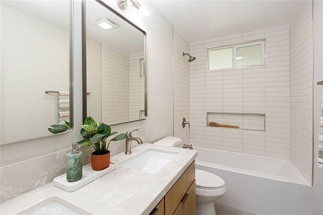 full bathroom featuring tiled shower / bath combo, toilet, and vanity