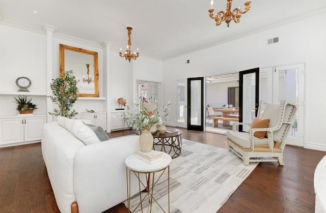 living room featuring french doors, ornamental molding, and a chandelier