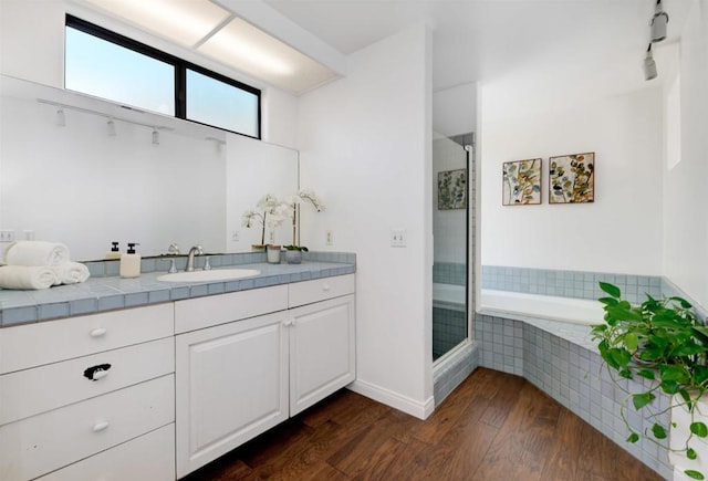 bathroom with hardwood / wood-style flooring, vanity, and independent shower and bath