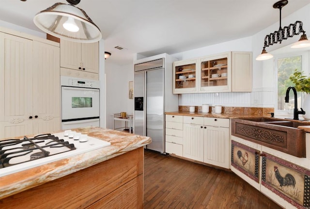 kitchen featuring sink, white appliances, tasteful backsplash, dark hardwood / wood-style flooring, and decorative light fixtures