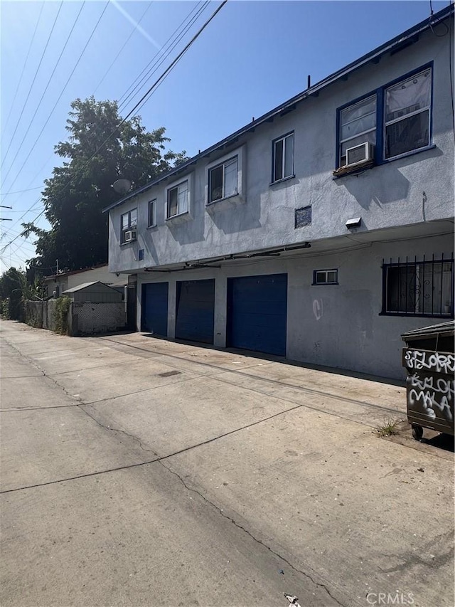 view of property exterior with cooling unit and a garage