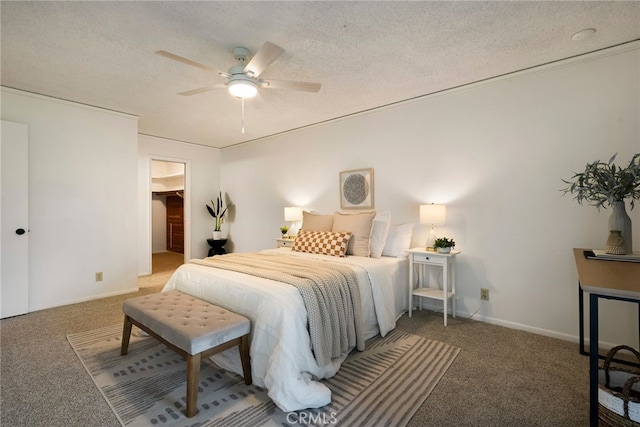 bedroom featuring ceiling fan, carpet, a spacious closet, and a textured ceiling