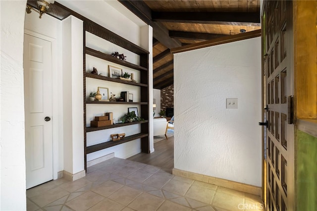 corridor with tile patterned flooring, vaulted ceiling with beams, built in features, and wooden ceiling