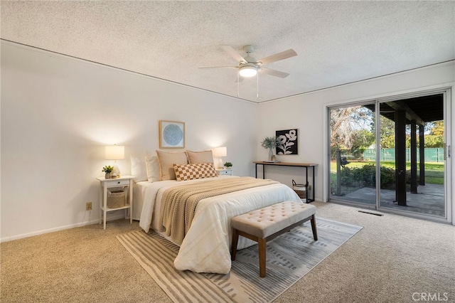 carpeted bedroom featuring access to exterior, a textured ceiling, and ceiling fan