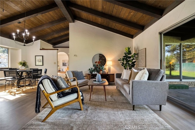 living room with an inviting chandelier, beamed ceiling, wood ceiling, and hardwood / wood-style flooring