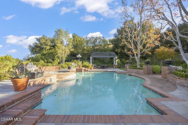 view of pool with a patio area and an in ground hot tub