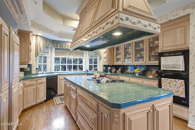 kitchen featuring crown molding, a center island, black appliances, and custom range hood