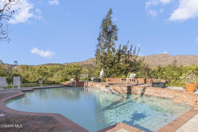 view of pool with a mountain view and a patio