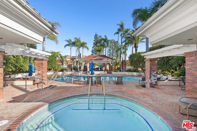 view of pool featuring a hot tub and a patio area