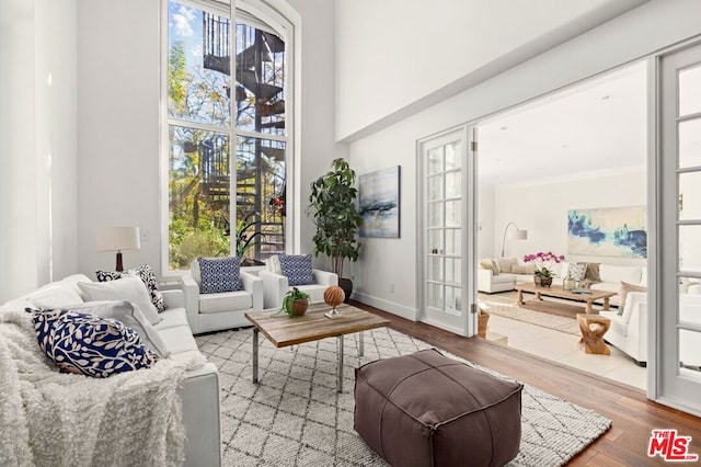 living area featuring wood-type flooring and crown molding