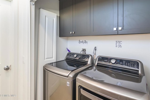 laundry room with washer and clothes dryer and cabinets