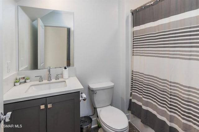 bathroom with curtained shower, vanity, and toilet