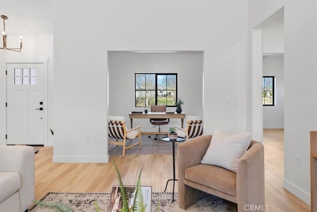 interior space featuring an inviting chandelier, wood finished floors, and baseboards