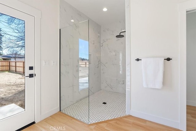 full bath featuring recessed lighting, wood finished floors, baseboards, and a marble finish shower