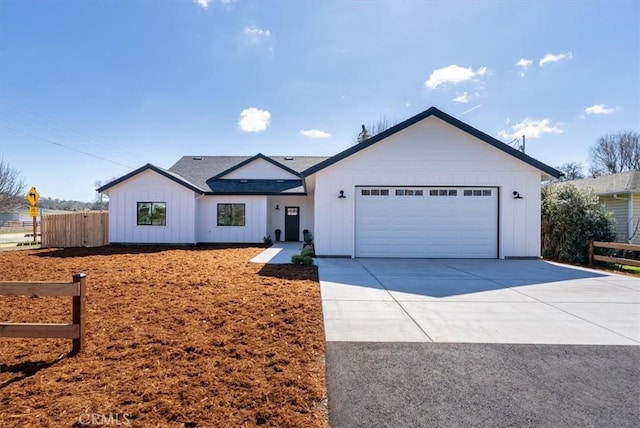 view of front of house featuring driveway, a garage, fence, and board and batten siding