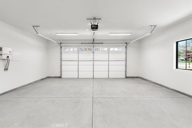 garage featuring a garage door opener and baseboards