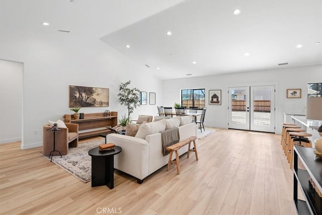 living area with recessed lighting, light wood-style floors, baseboards, and french doors