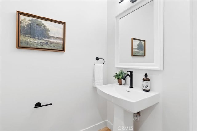 bathroom with a sink and baseboards