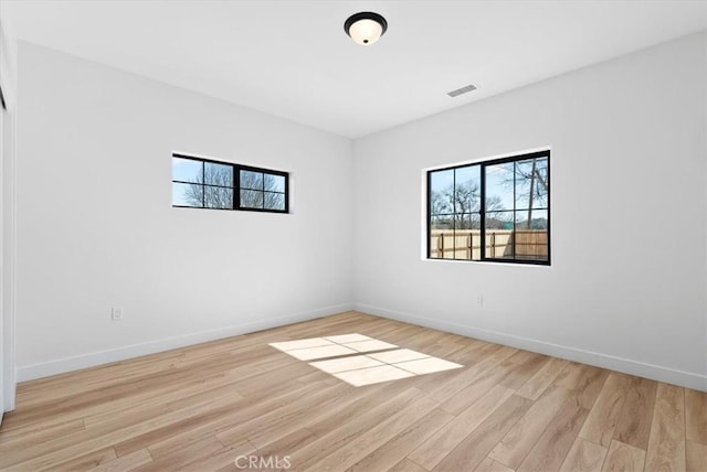 spare room with visible vents, baseboards, and light wood-style floors