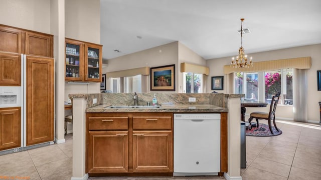 kitchen featuring pendant lighting, dishwasher, sink, light tile patterned floors, and a chandelier