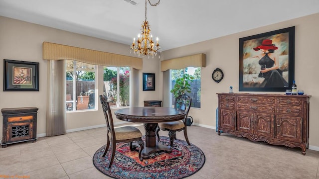 tiled dining room featuring a healthy amount of sunlight and a chandelier