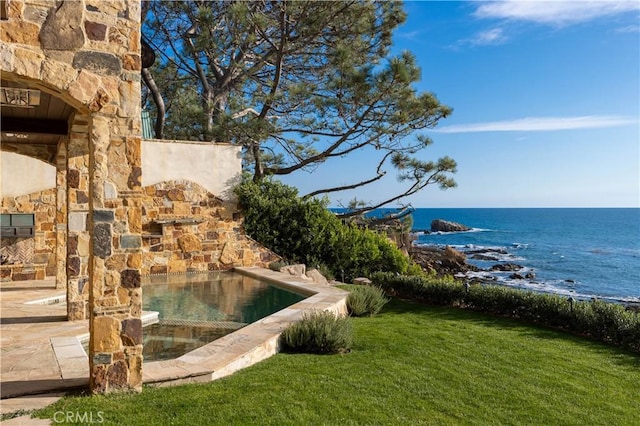 view of pool featuring a lawn, a jacuzzi, and a water view