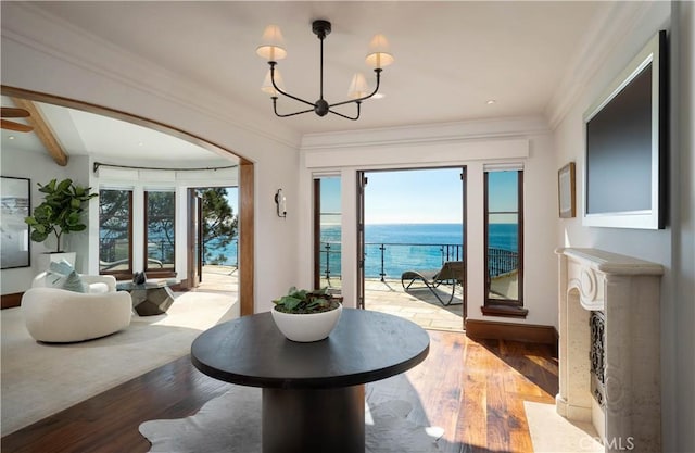 interior space with a chandelier, crown molding, a water view, and light hardwood / wood-style floors