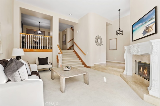 living room featuring a high end fireplace and light carpet