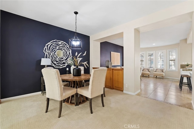 carpeted dining space featuring a chandelier