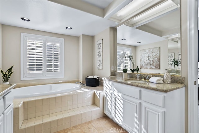 bathroom with tiled bath, a wealth of natural light, tile patterned flooring, and vanity