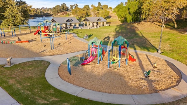 view of play area featuring a lawn and a water view