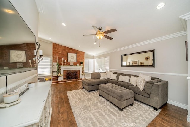 living room featuring a brick fireplace, hardwood / wood-style flooring, vaulted ceiling, and ornamental molding