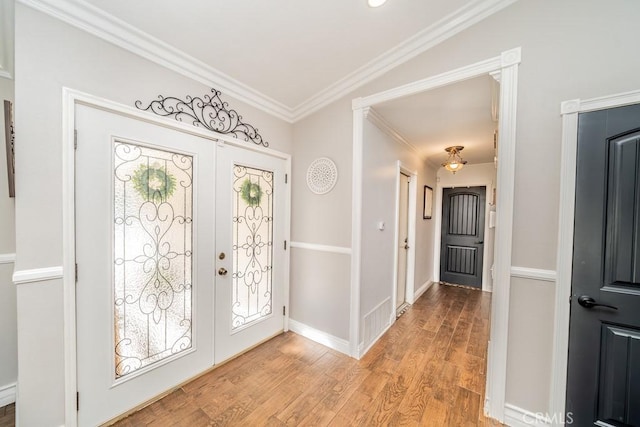 foyer with french doors, light hardwood / wood-style flooring, and ornamental molding