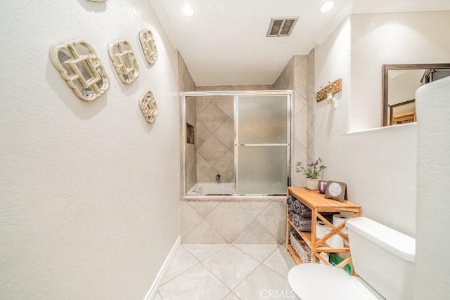 bathroom featuring combined bath / shower with glass door, tile patterned floors, crown molding, and toilet