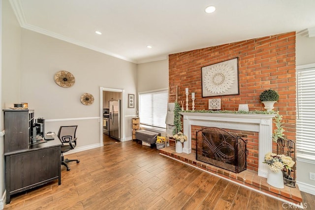 office featuring hardwood / wood-style floors, a brick fireplace, and crown molding