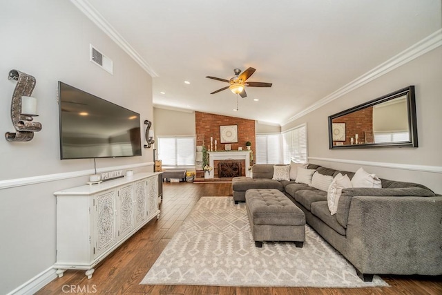 living room with light hardwood / wood-style floors, vaulted ceiling, ceiling fan, and ornamental molding