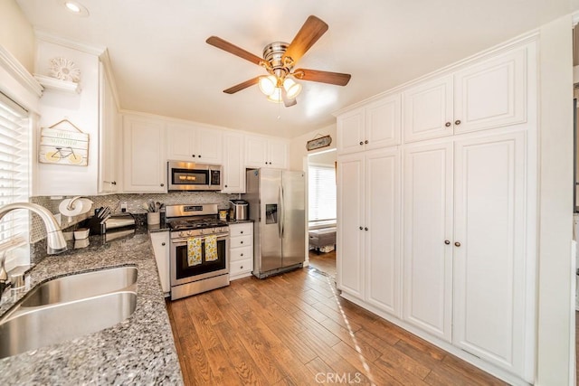 kitchen featuring sink, white cabinets, stainless steel appliances, and light hardwood / wood-style floors