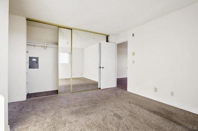 unfurnished bedroom featuring dark carpet, electric panel, and a closet