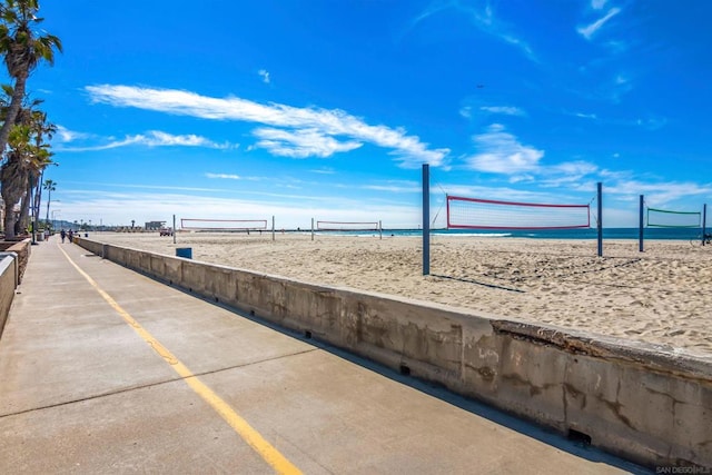 view of community with a beach view, volleyball court, and a water view