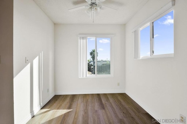 unfurnished room with hardwood / wood-style flooring, plenty of natural light, ceiling fan, and a textured ceiling