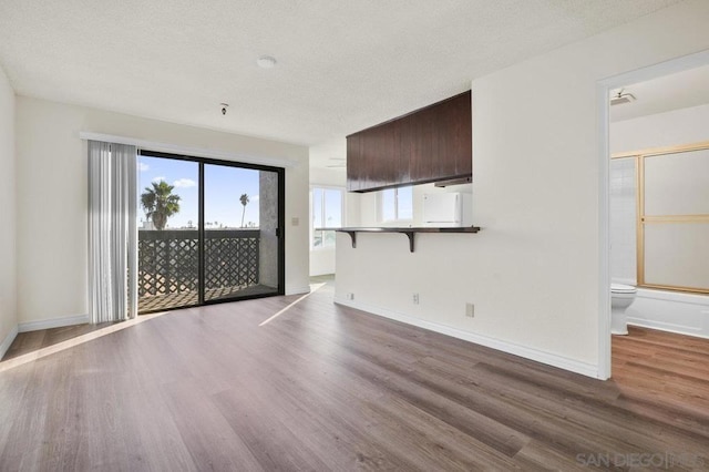 unfurnished living room with hardwood / wood-style floors and a textured ceiling