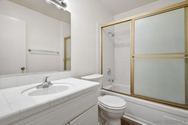 full bathroom with vanity, toilet, and bath / shower combo with glass door