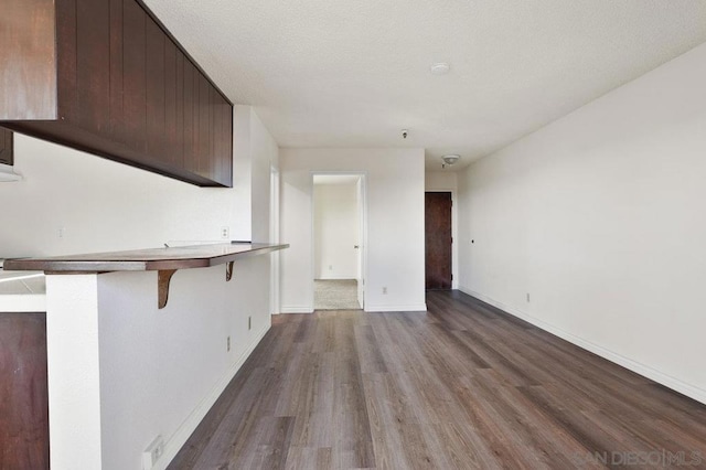 unfurnished living room featuring wood-type flooring and a textured ceiling