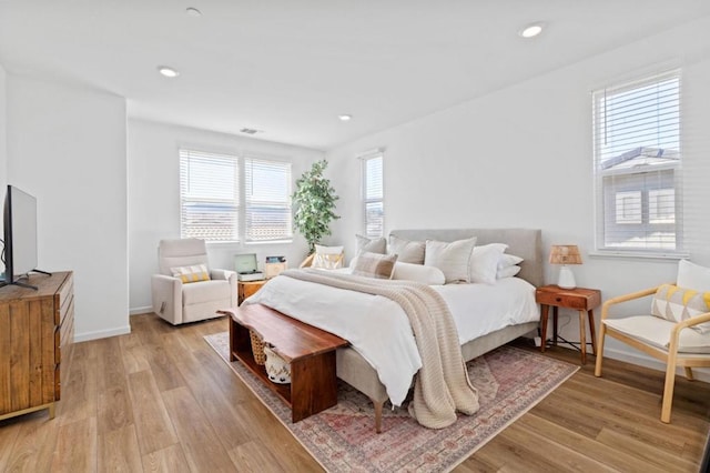 bedroom featuring multiple windows and light hardwood / wood-style flooring