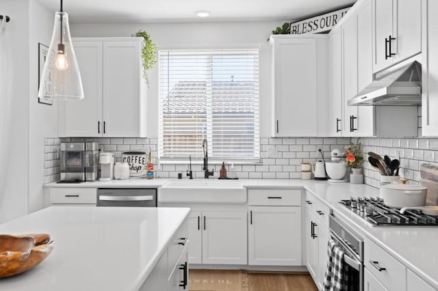 kitchen featuring hanging light fixtures, white cabinets, appliances with stainless steel finishes, and sink